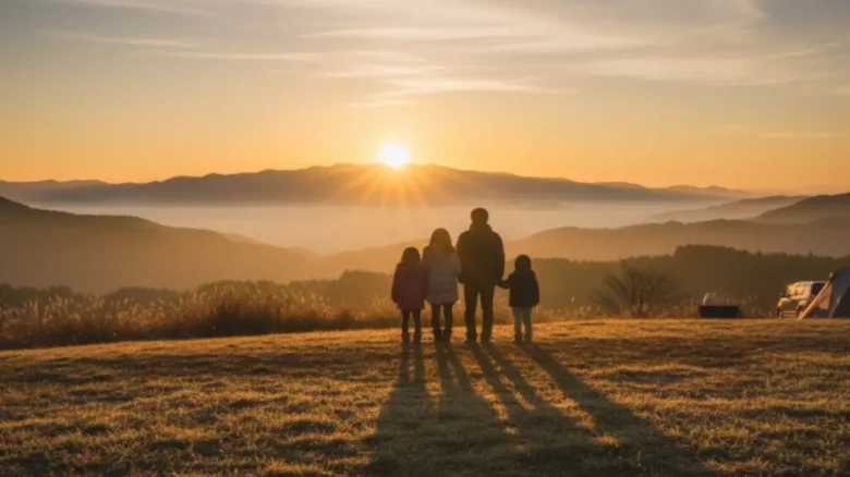 ひなもりオートキャンプ場で初日の出を眺める家族のシルエット